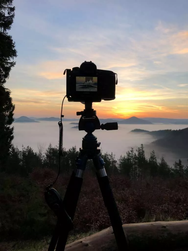 Timelaps Setup, Kameraufaufbau für Zeitraffer-Aufnahmen: Kamera mit kabelgebundenem Fernauslöser im Pfälzerwald bei Sonnenaufgang mit Blick über die nebelverhangenen Täler