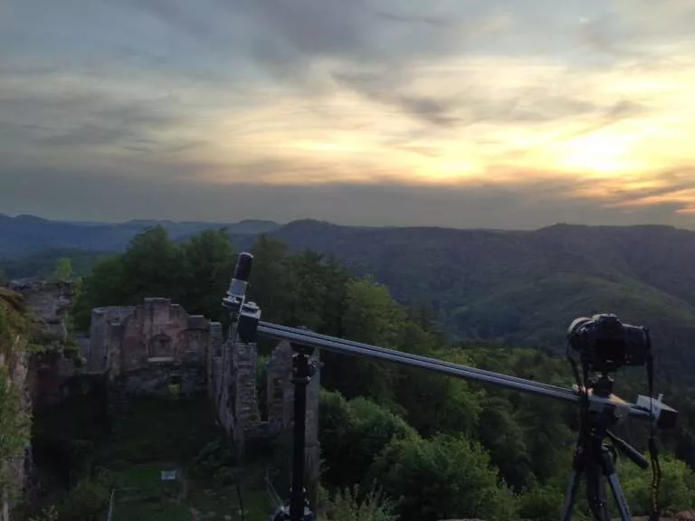 Kamera auf einem Slider steht an einem Aussichtspunkt bei einer Burgruine im Pfälzerwald und nimmt einen Zeitraffer / Timelapse auf.