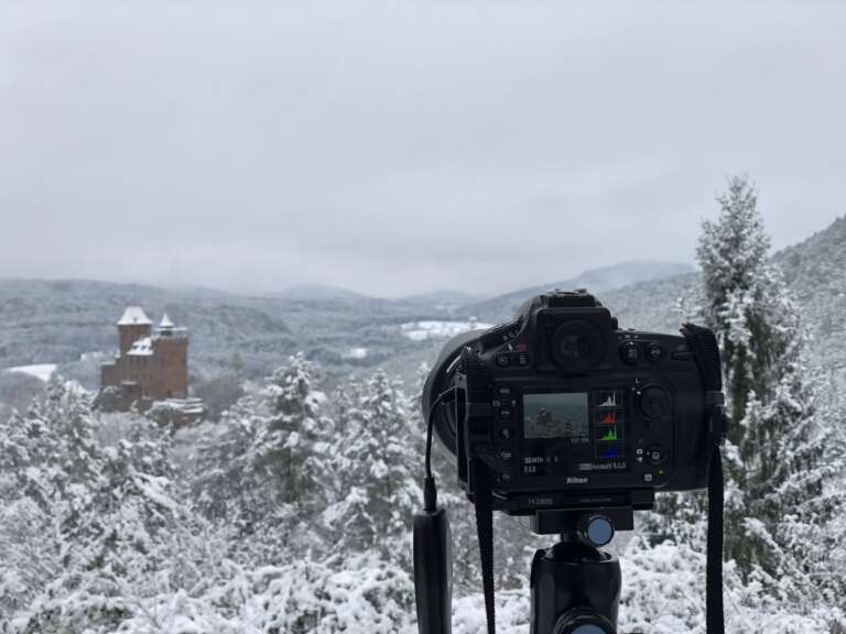 Eine Kamera von Stefan Engel steht im Winter auf einem Stativ an einem Aussichtspunkt im Pfälzerwald über dem Wolkenmeer. Die Kamera nimmt Bildserien für Timelapse auf.