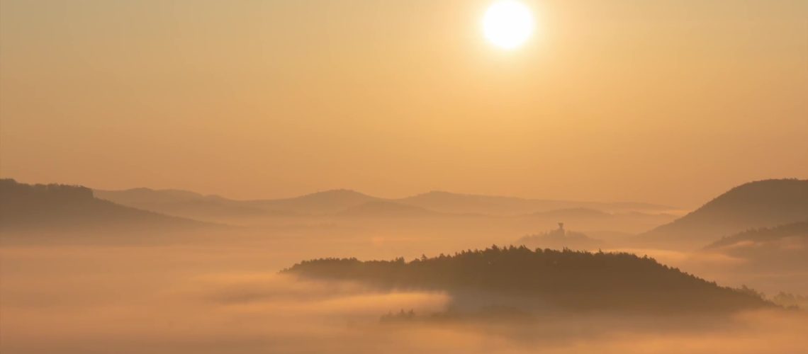 Ausschnitt aus einem Zeitraffervideo im Pfälzerwald, man sieht die aufgehende Sonne über Hügel und Bergen in der Pfalz mit nebelverhangenen Tälern